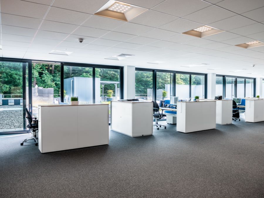 Büro mit Arbeitsplätzen, Pflanzen und Blick ins Grüne.